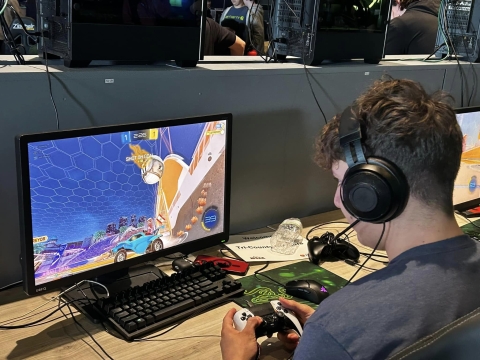 a young man plays a video game on a computer